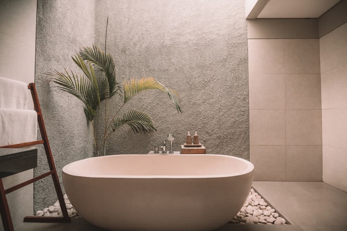 A stone soaking tub beside a fern, in one of the loft bathrooms